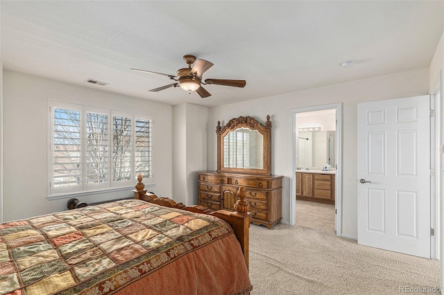 carpeted bedroom featuring ceiling fan and ensuite bathroom