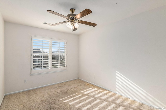 spare room with ceiling fan and light colored carpet