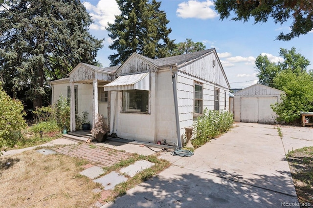 1832 S Saint Paul St, Denver, CO 80210 - view of front of home with concrete block siding, an outbuilding, and concrete driveway