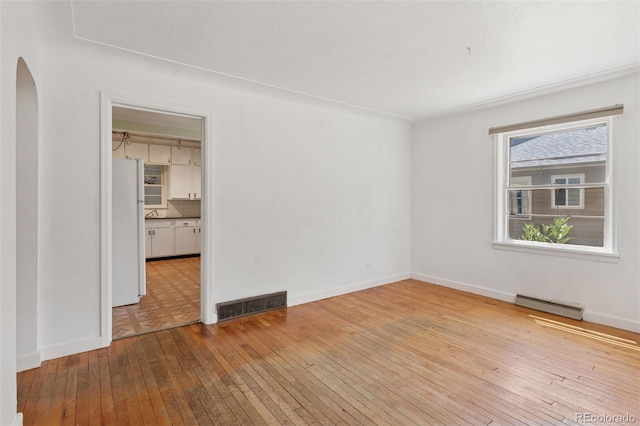 1832 S Saint Paul St, Denver, CO 80210 - empty room featuring arched walkways and hardwood / wood-style flooring