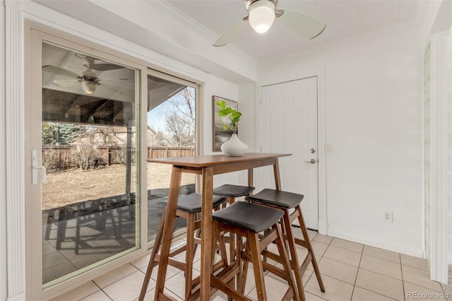 dining room with a ceiling fan, crown molding, and light tile patterned floors