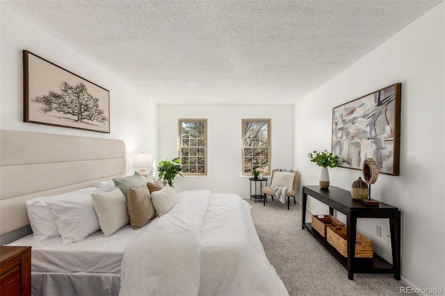 bedroom with carpet floors, baseboards, and a textured ceiling