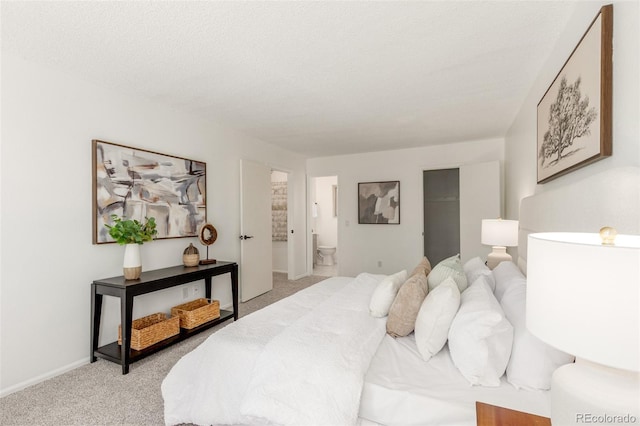 bedroom with light carpet, a textured ceiling, ensuite bath, and baseboards