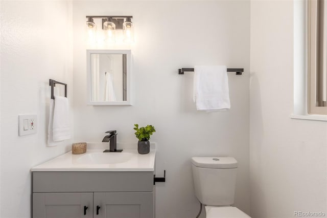 bathroom featuring toilet and vanity