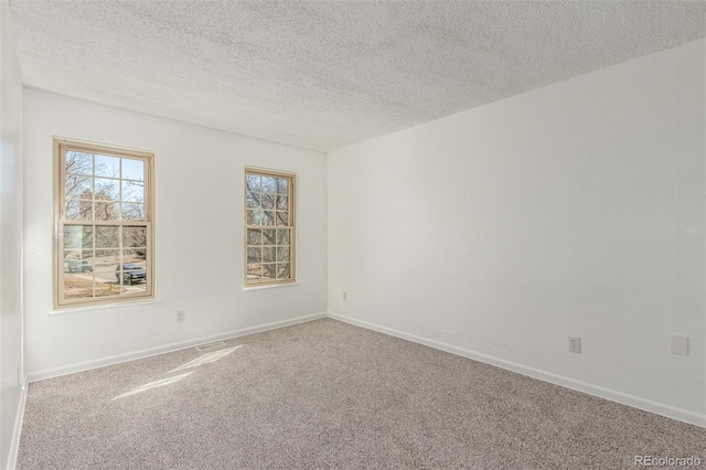 unfurnished room featuring a textured ceiling, baseboards, and carpet flooring