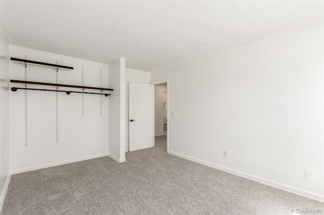 unfurnished bedroom with light carpet, a textured ceiling, and baseboards