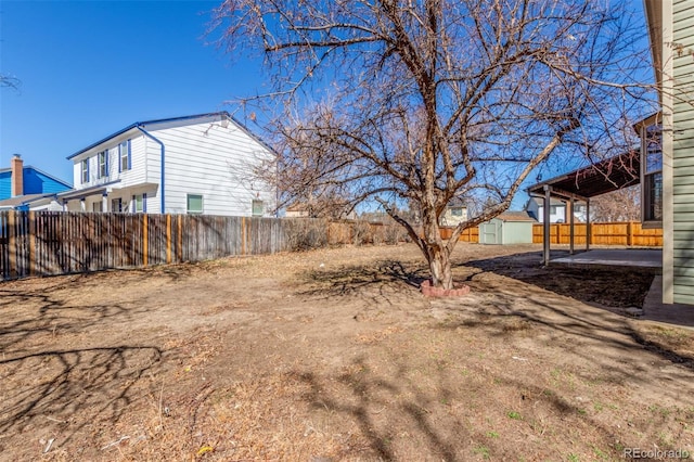 view of yard with a storage unit, an outdoor structure, and fence