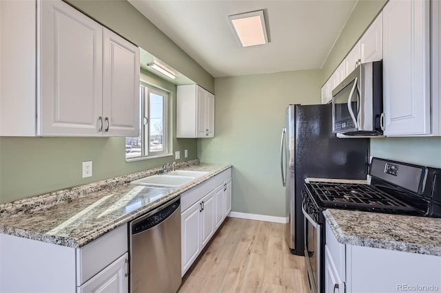 490 Washington Ave Unit A & B, Bennett, CO 80102 - kitchen with appliances with stainless steel finishes, light wood-style flooring, white cabinetry, and light countertops