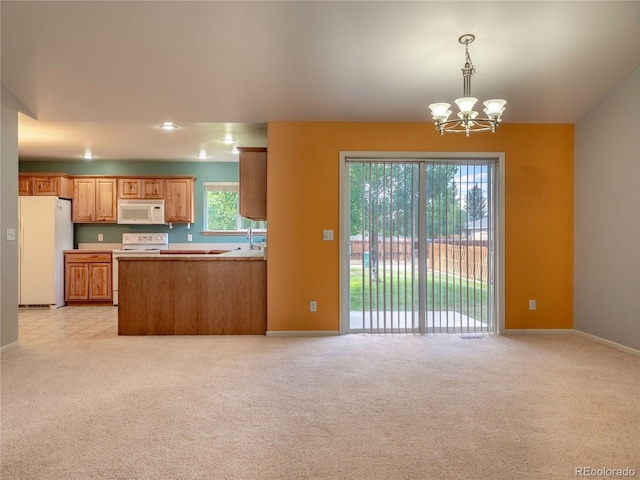 1436 H St Unit D, Salida, CO 81201 - kitchen with white appliances, a chandelier, light colored carpet, and hanging light fixtures