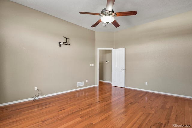 empty room with hardwood / wood-style flooring and ceiling fan