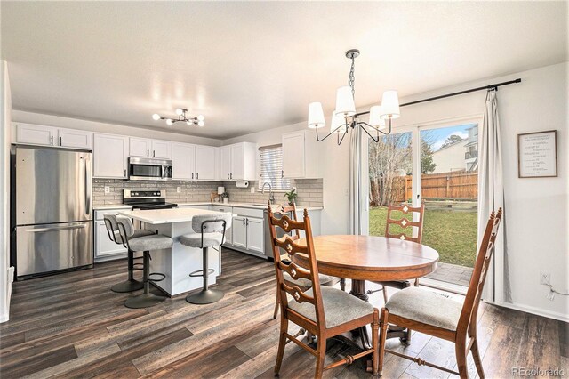 23813 Broadmoor Dr, Parker, CO 80138 - dining space featuring baseboards, plenty of natural light, a notable chandelier, and dark wood-style floors