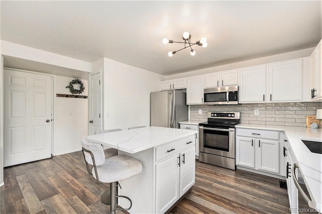23813 Broadmoor Dr, Parker, CO 80138 - kitchen with a kitchen island, an inviting chandelier, dark wood finished floors, and appliances with stainless steel finishes