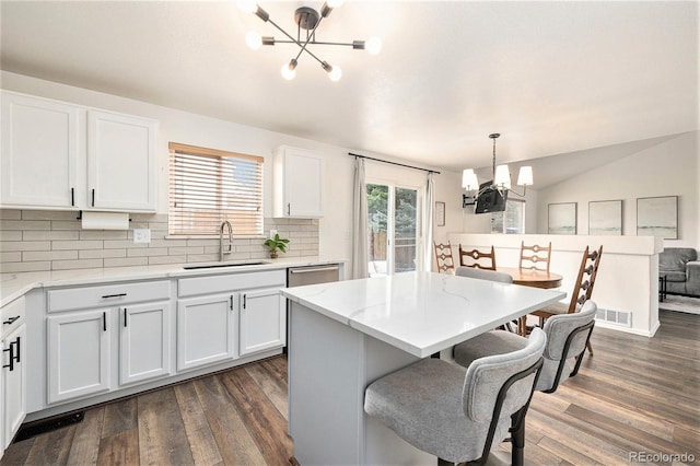 23813 Broadmoor Dr, Parker, CO 80138 - kitchen featuring a kitchen breakfast bar, white cabinets, dark wood-style flooring, a sink, and a notable chandelier