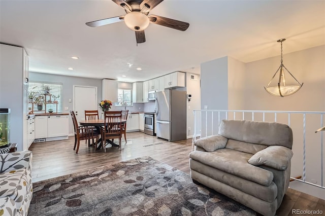 living area with recessed lighting and wood finished floors