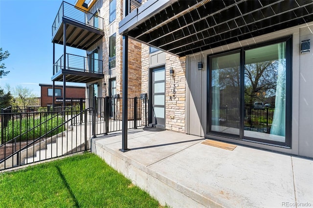 property entrance with a balcony and stone siding