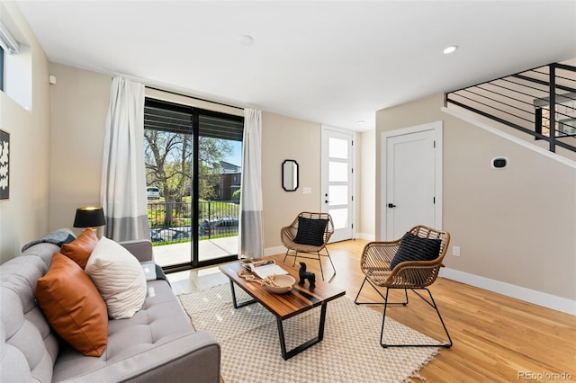 living area with light wood-style floors, baseboards, and recessed lighting
