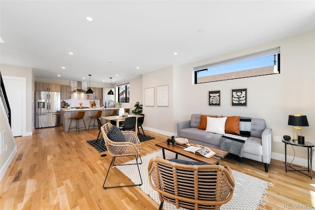 living room with light wood-style floors, baseboards, and recessed lighting