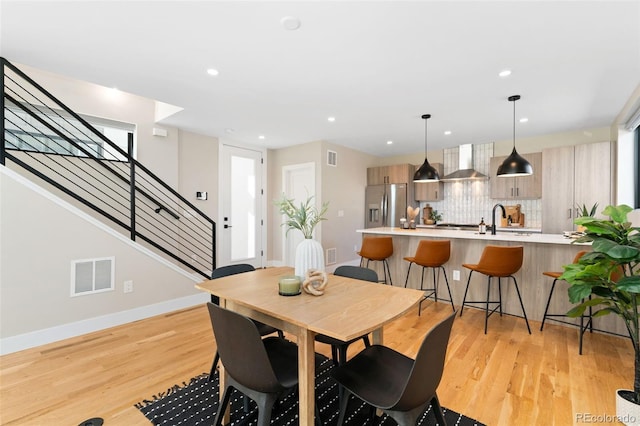 dining space featuring recessed lighting, baseboards, light wood-type flooring, visible vents, and stairway