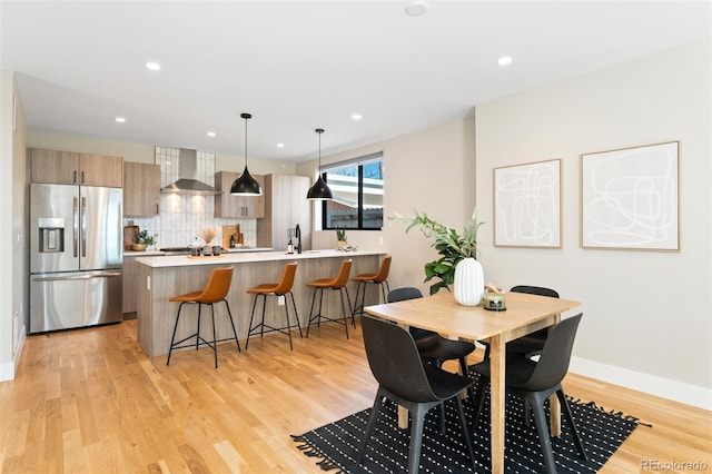 dining room featuring light wood-style floors, baseboards, and recessed lighting