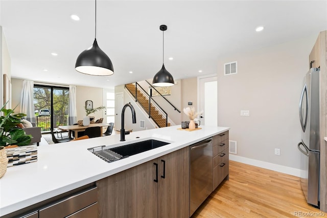 kitchen featuring visible vents, appliances with stainless steel finishes, modern cabinets, a sink, and light countertops