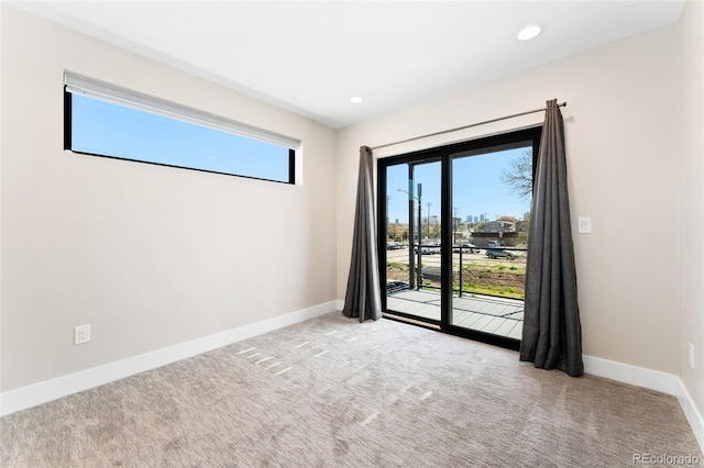 empty room with baseboards, recessed lighting, and light colored carpet