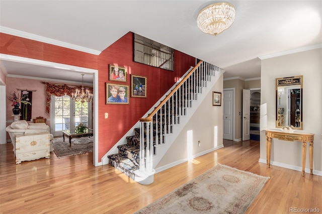 stairway with hardwood / wood-style floors, a chandelier, and ornamental molding