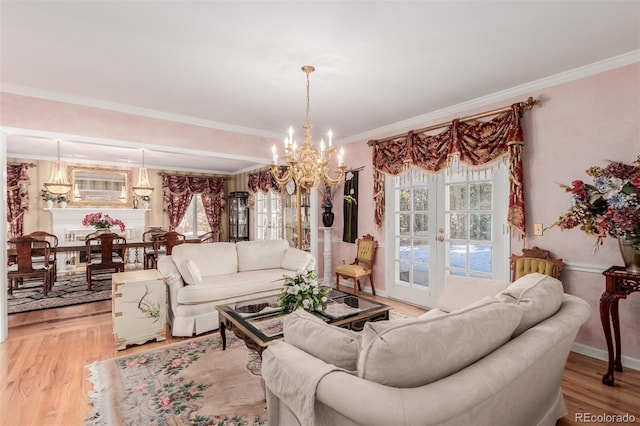 living room with hardwood / wood-style flooring, a notable chandelier, ornamental molding, and a wealth of natural light