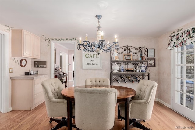 dining area featuring an inviting chandelier and light hardwood / wood-style flooring