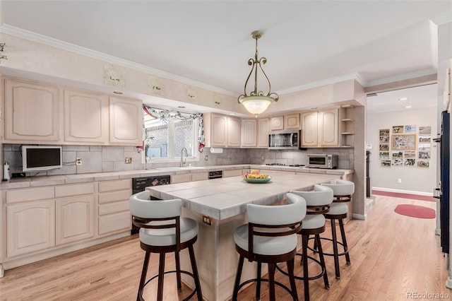 kitchen featuring a kitchen breakfast bar, a center island, light hardwood / wood-style floors, and tile counters