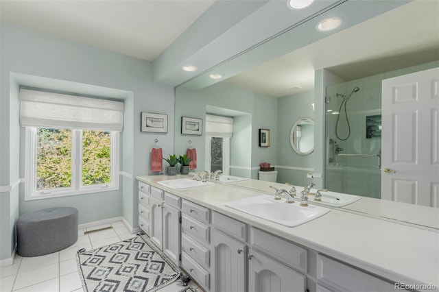 bathroom with a tile shower, tile patterned flooring, and vanity