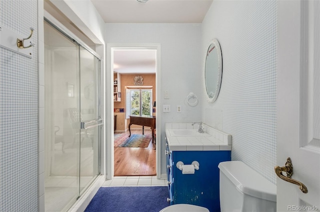 bathroom featuring tile patterned flooring, vanity, toilet, and a shower with shower door