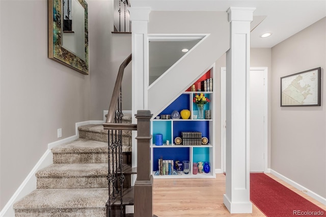 staircase featuring built in features and hardwood / wood-style floors