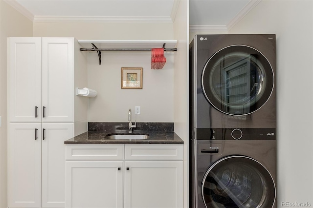 washroom featuring crown molding, cabinets, stacked washer and dryer, and sink