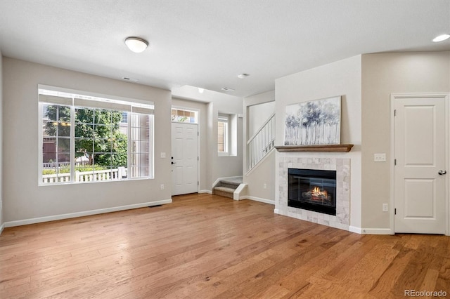 16062 W 62nd Ln, Arvada, CO 80403 - unfurnished living room with wood finished floors, stairs, and a fireplace