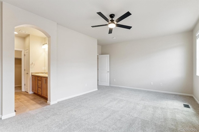 16062 W 62nd Ln, Arvada, CO 80403 - unfurnished bedroom with arched walkways, light colored carpet, ensuite bathroom, and a ceiling fan