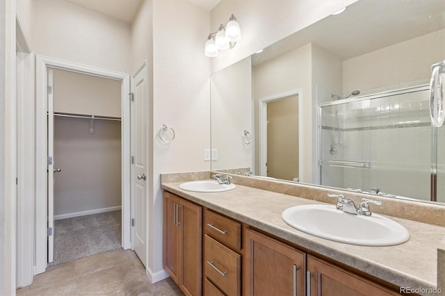 16062 W 62nd Ln, Arvada, CO 80403 - bathroom with a shower stall, a walk in closet, double vanity, and tile patterned floors