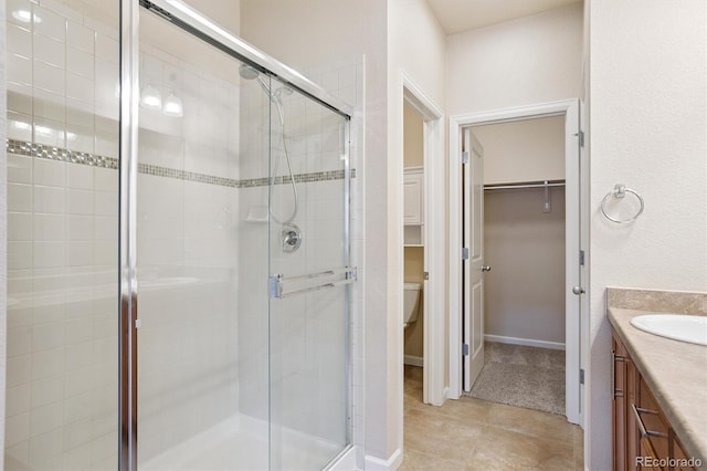 16062 W 62nd Ln, Arvada, CO 80403 - bathroom with a spacious closet, a shower stall, vanity, and tile patterned floors