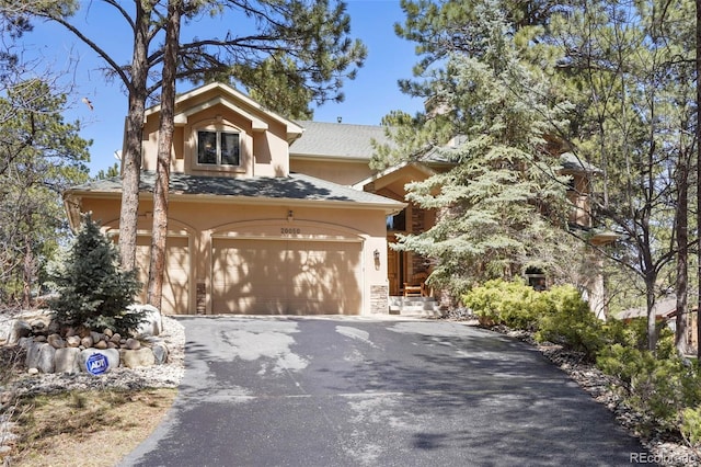 20050 Lost Arrowhead Dr, Monument, CO 80132 - view of property hidden behind natural elements with asphalt driveway and stucco siding