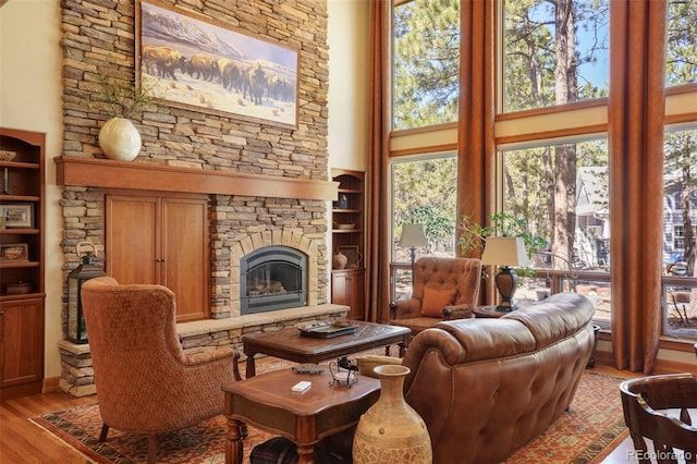 20050 Lost Arrowhead Dr, Monument, CO 80132 - living area featuring a towering ceiling, light wood-style flooring, a fireplace, and built in features