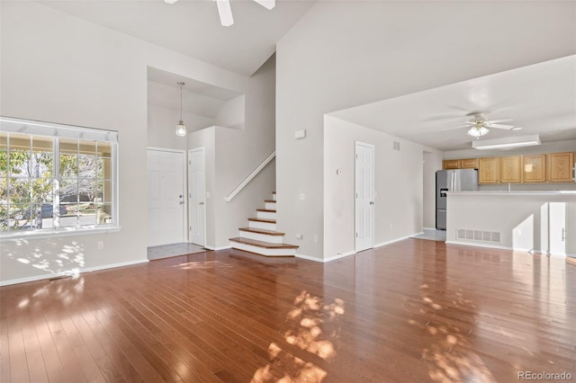 unfurnished living room with high vaulted ceiling, wood-type flooring, and ceiling fan