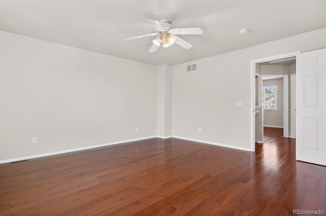 empty room with ceiling fan and dark hardwood / wood-style flooring