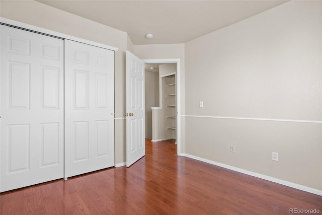 unfurnished bedroom with a closet and hardwood / wood-style flooring