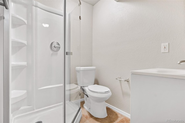 bathroom featuring vanity, toilet, tile patterned floors, and a shower with shower door