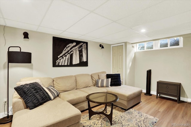 living room featuring light hardwood / wood-style floors and a drop ceiling