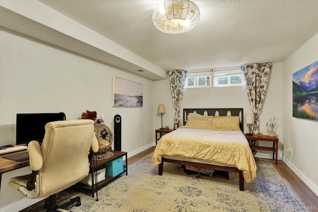 bedroom with hardwood / wood-style floors and a textured ceiling