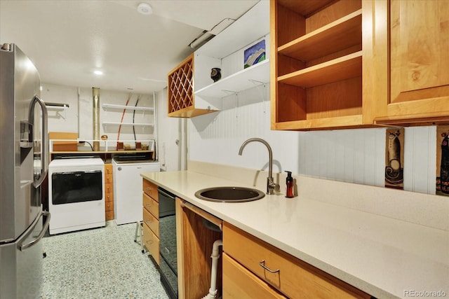 kitchen featuring stainless steel fridge, sink, and washer and dryer