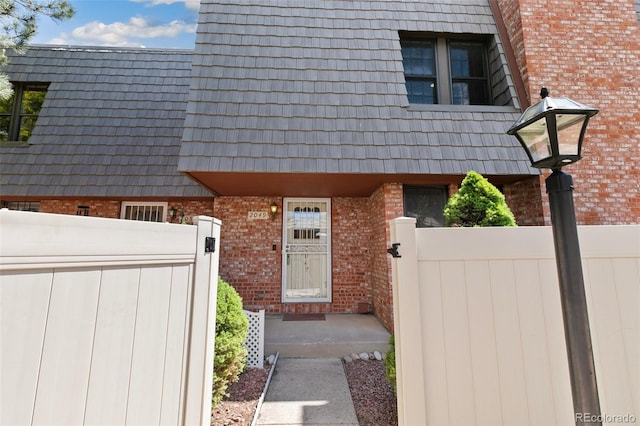 2049 Sussex Ln, Colorado Springs, CO 80909 - doorway to property featuring brick siding and mansard roof