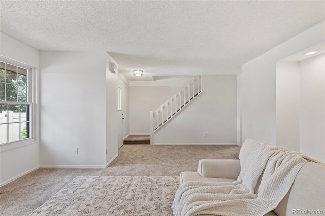 2049 Sussex Ln, Colorado Springs, CO 80909 - living area with carpet floors, a textured ceiling, and stairway