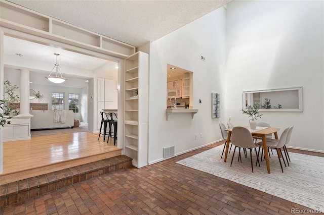 2049 Sussex Ln, Colorado Springs, CO 80909 - dining area with brick patterned flooring and a textured ceiling