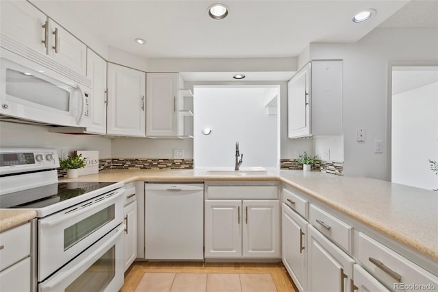 2049 Sussex Ln, Colorado Springs, CO 80909 - kitchen with white appliances, white cabinetry, light countertops, recessed lighting, and light tile patterned flooring